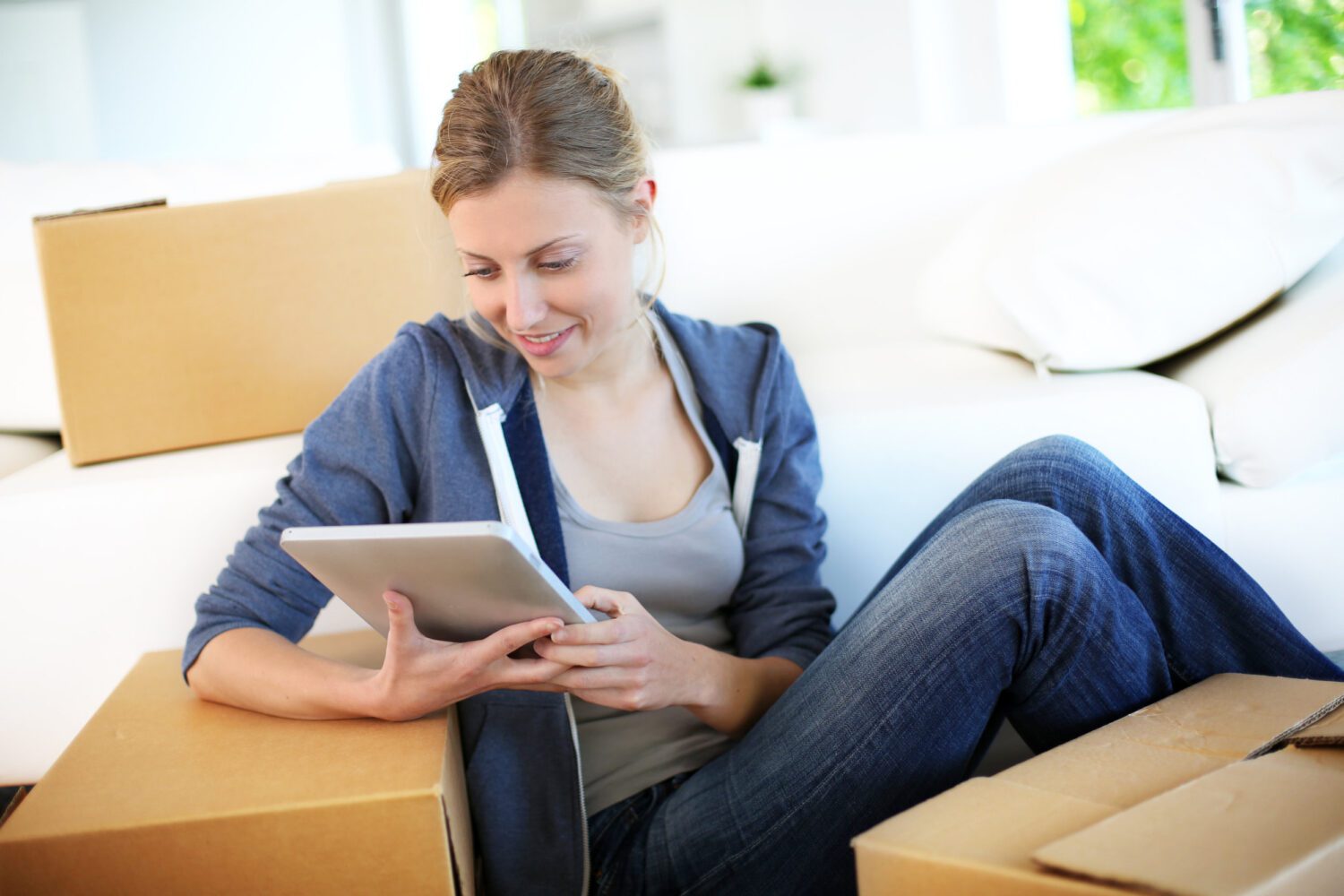 Young girl websurfing on tablet in new flat