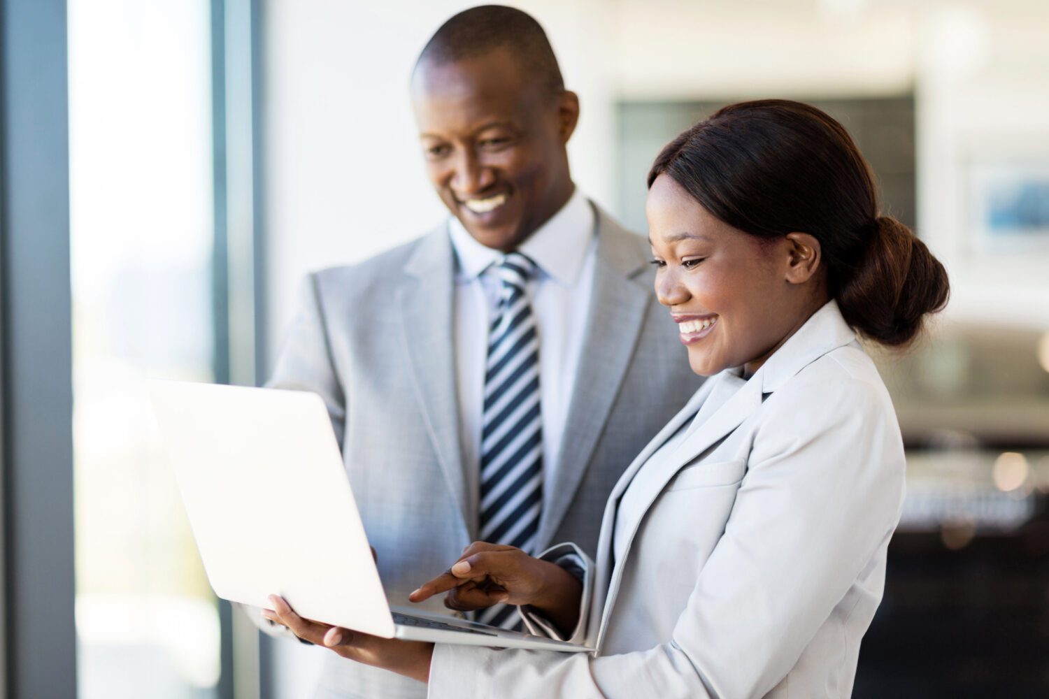 car sales consultants working on laptop computer